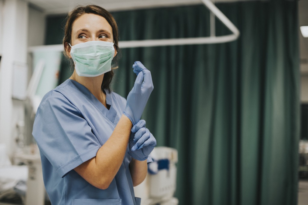 Nurse putting on gloves