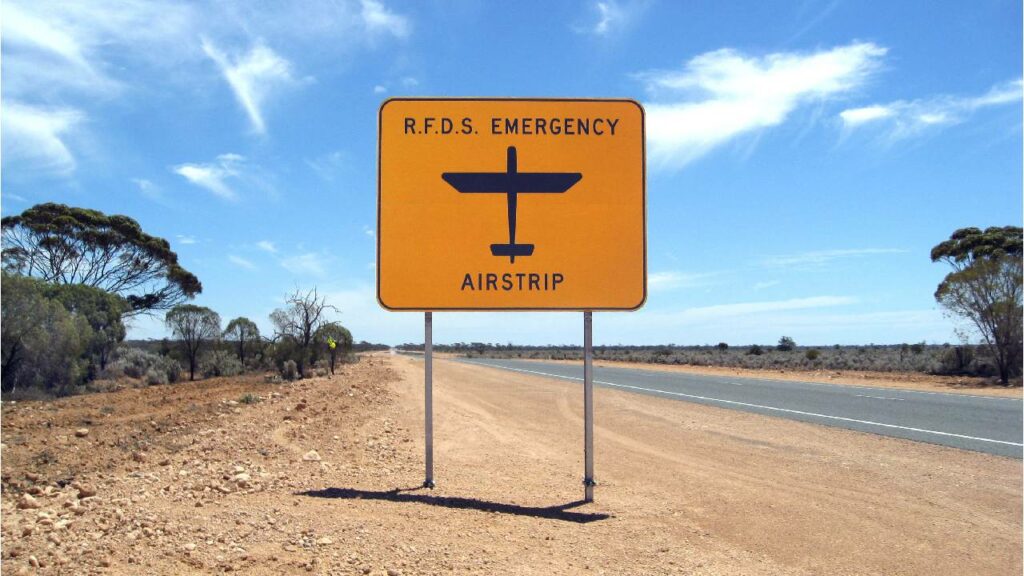 Sign saying "R.F.D.S Emergency Airstrip" in a remote outback town